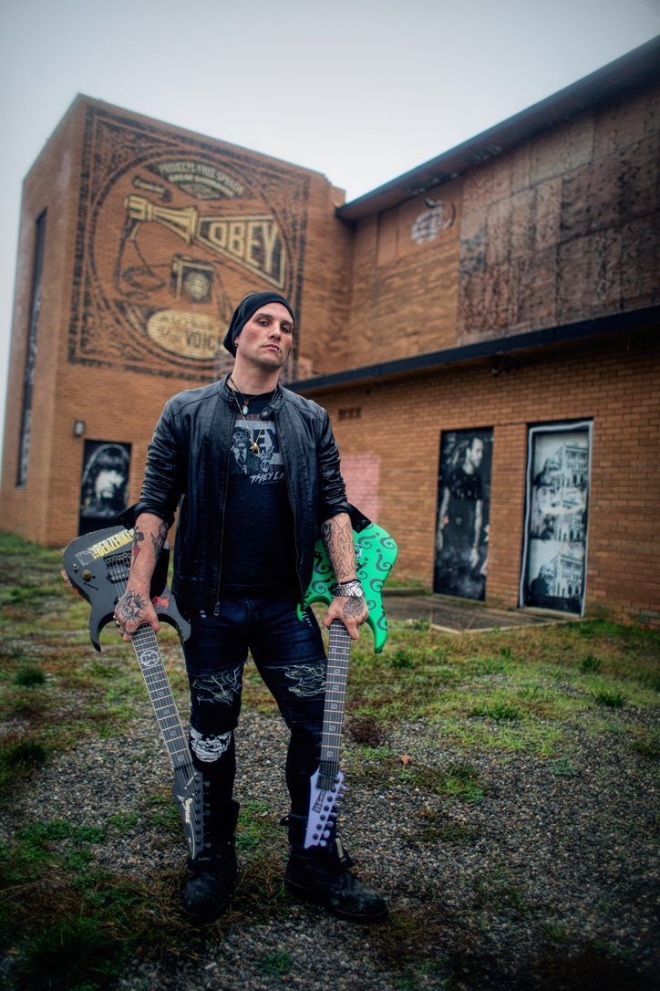 Holding two custom seven-string guitars