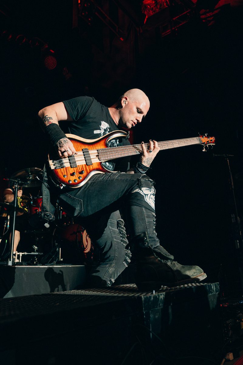 Sunburst flame-maple five-string bass live on stage