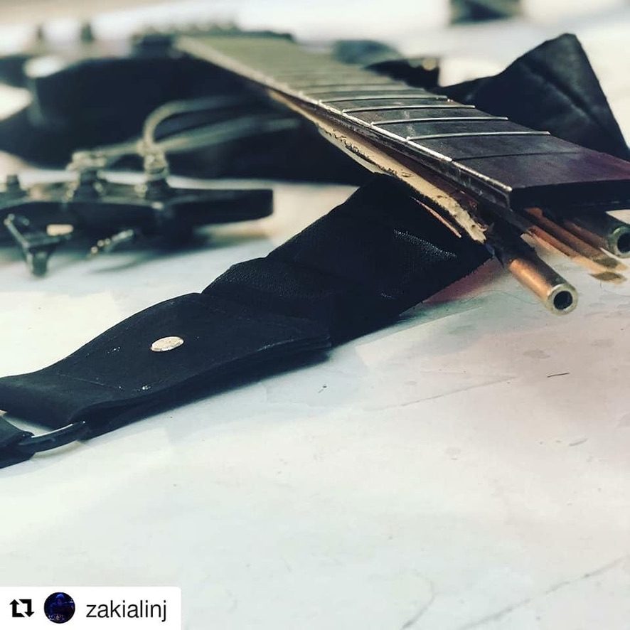 A bass with a snapped neck laid on a table