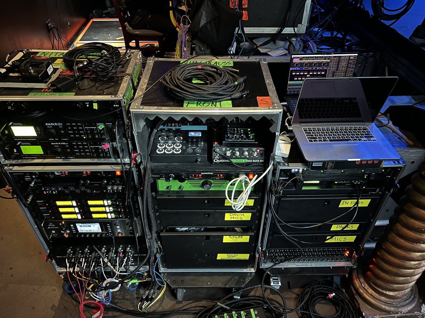 Production racks from the Nita Strauss years: Fractal Axe-Fx units, wireless and in-ear racks, labeled cases for drum mics, spares and in-ears, a Quilter head and a playback laptop